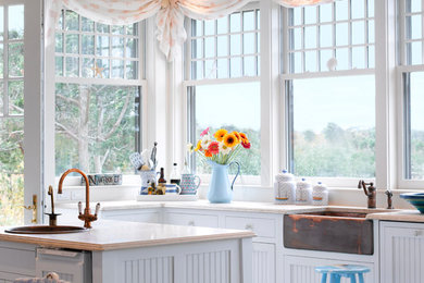 Источник вдохновения для домашнего уюта: кухня в морском стиле с обеденным столом, с полувстраиваемой мойкой (с передним бортиком), белыми фасадами и окном
