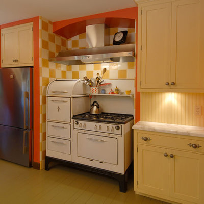 Enclosed kitchen - mid-sized eclectic l-shaped painted wood floor and beige floor enclosed kitchen idea in San Francisco with white appliances, yellow cabinets, wood backsplash, an undermount sink, shaker cabinets, marble countertops, yellow backsplash and a peninsula