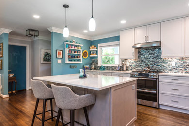 Mid-sized trendy single-wall medium tone wood floor and brown floor eat-in kitchen photo in Atlanta with recessed-panel cabinets, white cabinets, quartzite countertops, blue backsplash, mosaic tile backsplash, stainless steel appliances, an island and white countertops