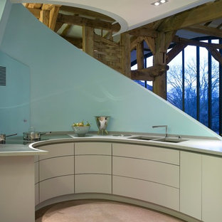 Cette image montre une grand cuisine ouverte design avec un évier encastré, un placard à porte plane, des portes de placard bleues, un plan de travail en surface solide, un électroménager blanc et une péninsule.