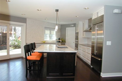 Enclosed kitchen - mid-sized transitional l-shaped dark wood floor and brown floor enclosed kitchen idea in DC Metro with an undermount sink, shaker cabinets, white cabinets, marble countertops, white backsplash, ceramic backsplash, stainless steel appliances, an island and white countertops