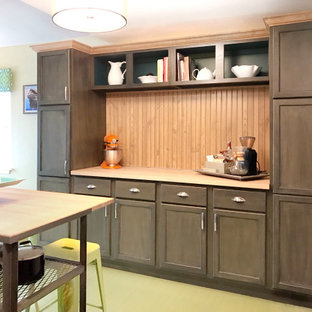 This is an example of a mid-sized transitional kitchen in Columbus with a drop-in sink, recessed-panel cabinets, dark wood cabinets, granite benchtops, green splashback, black appliances, painted wood floors, with island, green floor and green benchtop.