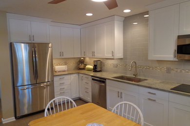 Example of a mid-sized transitional l-shaped linoleum floor eat-in kitchen design in Raleigh with an undermount sink, recessed-panel cabinets, white cabinets, granite countertops, gray backsplash, subway tile backsplash, stainless steel appliances and no island