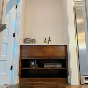 Réalisation d'une grand cuisine américaine parallèle tradition avec un évier de ferme, un placard avec porte à panneau encastré, des portes de placard blanches, un plan de travail en quartz modifié, une crédence bleue, une crédence en carreau de céramique, un électroménager en acier inoxydable, un sol en bois brun, un îlot central, un sol marron, un plan de travail blanc et un plafond en lambris de bois.