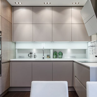 Esempio di una cucina contemporanea con ante lisce, ante beige, elettrodomestici in acciaio inossidabile, top in superficie solida e paraspruzzi bianco
