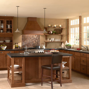 Photo of a large country l-shaped eat-in kitchen in Orange County with medium wood cabinets, with island, a drop-in sink, shaker cabinets, solid surface benchtops, metallic splashback, metal splashback, stainless steel appliances, ceramic floors and beige floor.