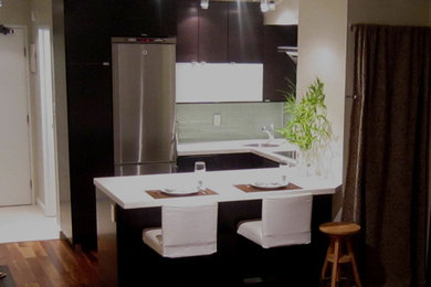 Moderne Wohnküche in U-Form mit Unterbauwaschbecken, flächenbündigen Schrankfronten, dunklen Holzschränken, Quarzwerkstein-Arbeitsplatte, Küchenrückwand in Grün, Rückwand aus Glasfliesen und Küchengeräten aus Edelstahl in Vancouver