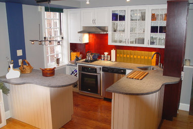 Inspiration for a small contemporary u-shaped medium tone wood floor and brown floor kitchen remodel in Philadelphia with an undermount sink, raised-panel cabinets, white cabinets, red backsplash, stainless steel appliances, no island, gray countertops and ceramic backsplash