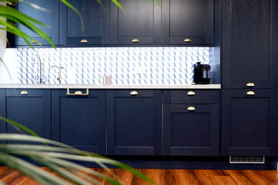 マンチェスターにあるお手頃価格の小さなコンテンポラリースタイルのおしゃれなキッチン (ドロップインシンク、落し込みパネル扉のキャビネット、青いキャビネット、ラミネートカウンター、青いキッチンパネル、セメントタイルのキッチンパネル、パネルと同色の調理設備、ラミネートの床、アイランドなし、茶色い床、グレーのキッチンカウンター) の写真