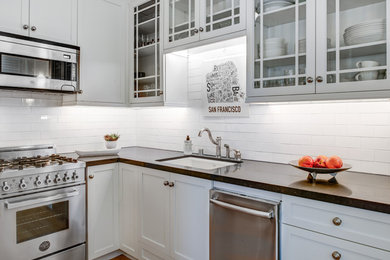 Example of a small trendy galley light wood floor kitchen pantry design in San Francisco with an undermount sink, shaker cabinets, white cabinets, quartz countertops, brown backsplash, ceramic backsplash, stainless steel appliances and no island