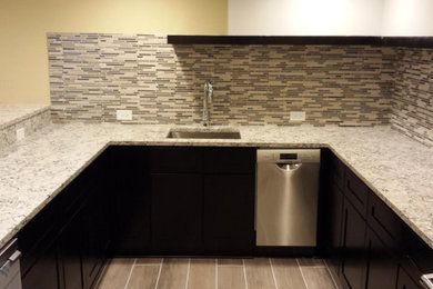 Enclosed kitchen - small traditional u-shaped vinyl floor and brown floor enclosed kitchen idea in Chicago with an undermount sink, shaker cabinets, black cabinets, granite countertops, multicolored backsplash, matchstick tile backsplash, stainless steel appliances, a peninsula and multicolored countertops