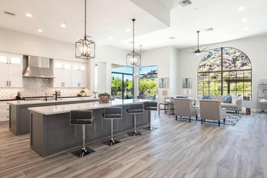 Open concept kitchen - huge contemporary l-shaped gray floor open concept kitchen idea in San Francisco with two islands, a farmhouse sink, stainless steel appliances, white countertops, shaker cabinets, white cabinets and multicolored backsplash