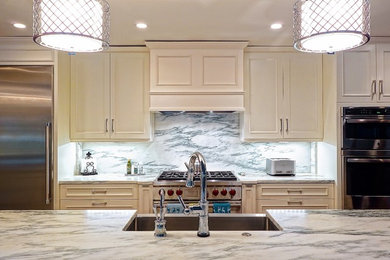 Example of a large classic l-shaped dark wood floor open concept kitchen design in Louisville with a farmhouse sink, recessed-panel cabinets, white cabinets, marble countertops, white backsplash, stone slab backsplash, stainless steel appliances and an island