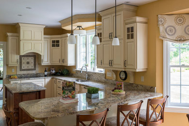 Inspiration for a mid-sized timeless u-shaped light wood floor and beige floor eat-in kitchen remodel in Boston with an undermount sink, raised-panel cabinets, white cabinets, granite countertops, yellow backsplash, marble backsplash, stainless steel appliances, an island and multicolored countertops