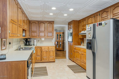 Eat-in kitchen - large eclectic galley light wood floor eat-in kitchen idea in Other with an undermount sink, shaker cabinets, gray cabinets, granite countertops, yellow backsplash, ceramic backsplash, stainless steel appliances, an island and multicolored countertops