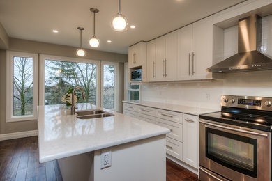 Transitional medium tone wood floor kitchen photo in Toronto with an undermount sink, shaker cabinets, white cabinets, quartzite countertops, white backsplash, stainless steel appliances and an island