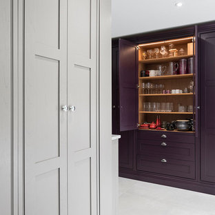 This is an example of an expansive country open plan kitchen in Surrey with a farmhouse sink, shaker cabinets, purple cabinets, granite benchtops, beige splashback, glass sheet splashback, stainless steel appliances, ceramic floors, with island, grey floor and multi-coloured benchtop.