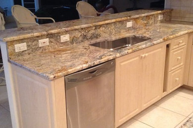 Elegant l-shaped eat-in kitchen photo in Miami with granite countertops and an island