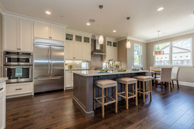 Inspiration for a mid-sized transitional u-shaped medium tone wood floor and brown floor eat-in kitchen remodel in San Francisco with an undermount sink, shaker cabinets, white cabinets, gray backsplash, subway tile backsplash, stainless steel appliances, an island, gray countertops and granite countertops