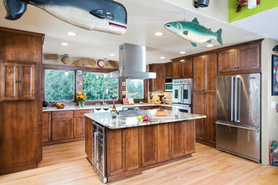 Large eclectic u-shaped light wood floor and brown floor open concept kitchen photo in Portland with a farmhouse sink, shaker cabinets, medium tone wood cabinets, granite countertops, beige backsplash, ceramic backsplash, stainless steel appliances, an island and multicolored countertops