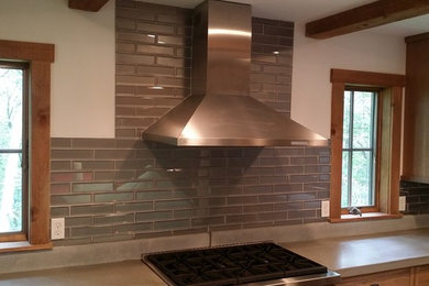 Example of a large cottage u-shaped eat-in kitchen design in New York with a farmhouse sink, shaker cabinets, medium tone wood cabinets, concrete countertops, gray backsplash, glass tile backsplash, stainless steel appliances and an island