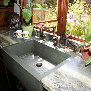 Inspiration for a mid-sized eclectic u-shaped eat-in kitchen in San Francisco with a farmhouse sink, flat-panel cabinets, medium wood cabinets, marble benchtops, green splashback, stone slab splashback, panelled appliances, porcelain floors and a peninsula.