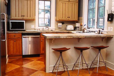 Inspiration for a small southwestern l-shaped concrete floor enclosed kitchen remodel in Chicago with an undermount sink, shaker cabinets, light wood cabinets, laminate countertops, white backsplash, mosaic tile backsplash, stainless steel appliances and a peninsula