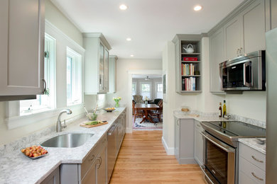 Inspiration for a transitional light wood floor kitchen remodel in Boston with an undermount sink, recessed-panel cabinets, gray cabinets and stainless steel appliances