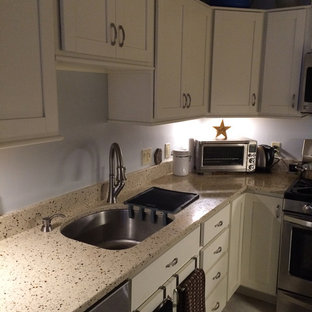 Photo of a small transitional galley separate kitchen in Boston with an undermount sink, shaker cabinets, white cabinets, recycled glass benchtops, stainless steel appliances, linoleum floors, no island, grey floor and white benchtop.