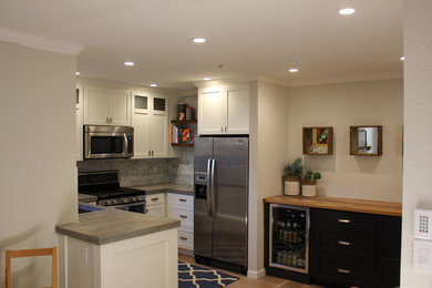Eat-in kitchen - small modern u-shaped light wood floor eat-in kitchen idea in San Francisco with an undermount sink, shaker cabinets, white cabinets, concrete countertops, gray backsplash, stone tile backsplash, stainless steel appliances and no island