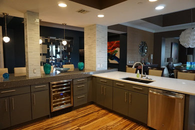 Inspiration for a mid-sized modern vinyl floor and brown floor open concept kitchen remodel in Tampa with an undermount sink, glass-front cabinets, gray cabinets, recycled glass countertops, gray backsplash, matchstick tile backsplash, stainless steel appliances and a peninsula