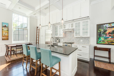 Open concept kitchen - large farmhouse single-wall dark wood floor and brown floor open concept kitchen idea in Boston with an undermount sink, shaker cabinets, white cabinets, solid surface countertops, gray backsplash, cement tile backsplash, stainless steel appliances and an island