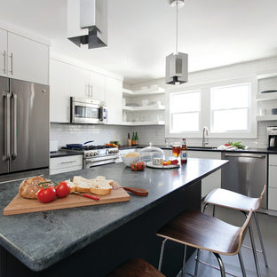 Large contemporary eat-in kitchen designs - Example of a large trendy u-shaped concrete floor and gray floor eat-in kitchen design in Bridgeport with white cabinets, white backsplash, stainless steel appliances, an island, an undermount sink, flat-panel cabinets, granite countertops and ceramic backsplash