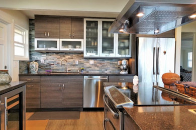 Large contemporary l-shaped kitchen pantry in Hawaii with a submerged sink, flat-panel cabinets, grey cabinets, engineered stone countertops, blue splashback, glass tiled splashback, stainless steel appliances, vinyl flooring and an island.