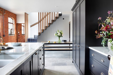 Contemporary galley kitchen/diner in Other with shaker cabinets, black cabinets, granite worktops, an island and white worktops.