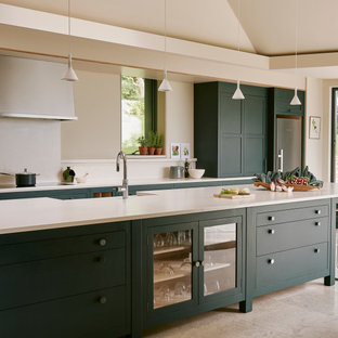 Design ideas for an expansive traditional kitchen in Other with a belfast sink, shaker cabinets, green cabinets, composite countertops, limestone flooring, an island, white splashback, beige floors and white worktops.
