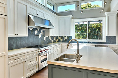 Inspiration for a contemporary l-shaped medium tone wood floor eat-in kitchen remodel in San Francisco with an undermount sink, white cabinets, quartz countertops, blue backsplash, ceramic backsplash, stainless steel appliances, an island and recessed-panel cabinets
