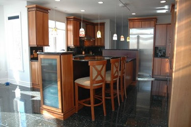 Example of a trendy u-shaped enclosed kitchen design in Indianapolis with an undermount sink, flat-panel cabinets, medium tone wood cabinets, granite countertops, stainless steel appliances and an island