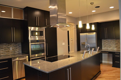 Example of a trendy u-shaped kitchen design in Richmond with an undermount sink, flat-panel cabinets, black cabinets, quartz countertops, multicolored backsplash, glass tile backsplash, stainless steel appliances and an island