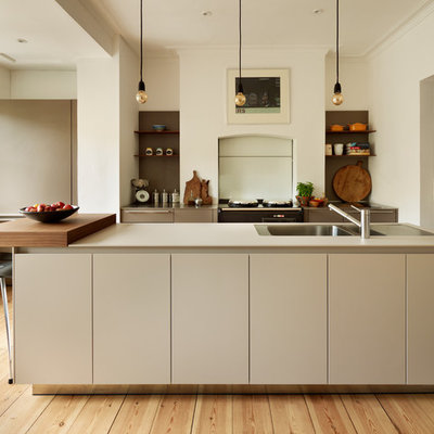 Kitchen - contemporary light wood floor kitchen idea in Oxfordshire with a double-bowl sink, flat-panel cabinets, white cabinets and an island