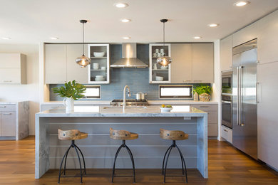 サンディエゴにある高級な中くらいなコンテンポラリースタイルのおしゃれなアイランドキッチン (グレーのキャビネット、青いキッチンパネル、シルバーの調理設備、無垢フローリング) の写真