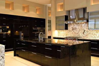 Photo of a large contemporary l-shaped enclosed kitchen in Phoenix with a submerged sink, flat-panel cabinets, black cabinets, granite worktops, multi-coloured splashback, stone slab splashback, stainless steel appliances, porcelain flooring, an island and beige floors.