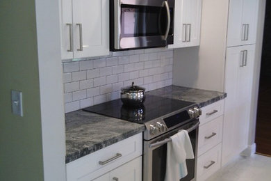 Mid-sized trendy u-shaped ceramic tile open concept kitchen photo in Miami with an undermount sink, shaker cabinets, white cabinets, granite countertops, white backsplash, subway tile backsplash, stainless steel appliances and an island