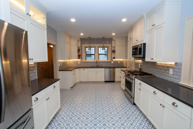 Large trendy u-shaped multicolored floor and ceramic tile eat-in kitchen photo in Other with gray backsplash, stainless steel appliances, no island, gray countertops, shaker cabinets, white cabinets, quartz countertops, an undermount sink and ceramic backsplash