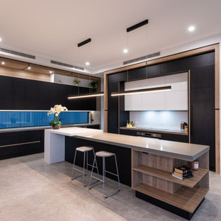 Photo of a contemporary l-shaped open plan kitchen in Gold Coast - Tweed with an undermount sink, flat-panel cabinets, black cabinets, white splashback, concrete floors, with island, grey floor and grey benchtop.