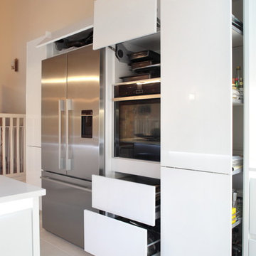 Contemporary handle-less white kitchen with a variety of storage options
