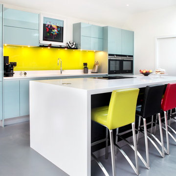 Contemporary high gloss kitchen with large island and bright bar stools