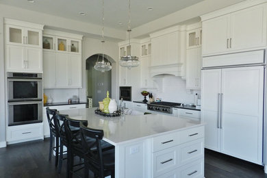 Eat-in kitchen - large contemporary l-shaped dark wood floor eat-in kitchen idea in Salt Lake City with a farmhouse sink, recessed-panel cabinets, white cabinets, granite countertops, white backsplash, ceramic backsplash, stainless steel appliances and an island