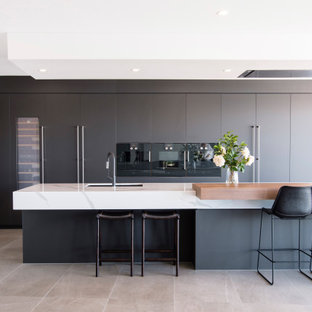 Inspiration for a contemporary galley kitchen in Brisbane with an undermount sink, flat-panel cabinets, grey cabinets, black appliances, with island, grey floor and white benchtop.