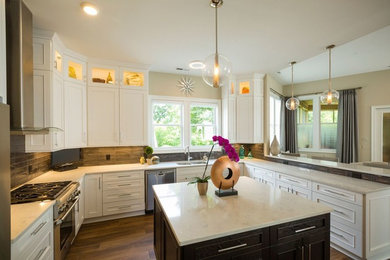 This is an example of a large classic u-shaped open plan kitchen in Other with a submerged sink, shaker cabinets, white cabinets, marble worktops, brown splashback, glass tiled splashback, stainless steel appliances, medium hardwood flooring, brown floors and multiple islands.